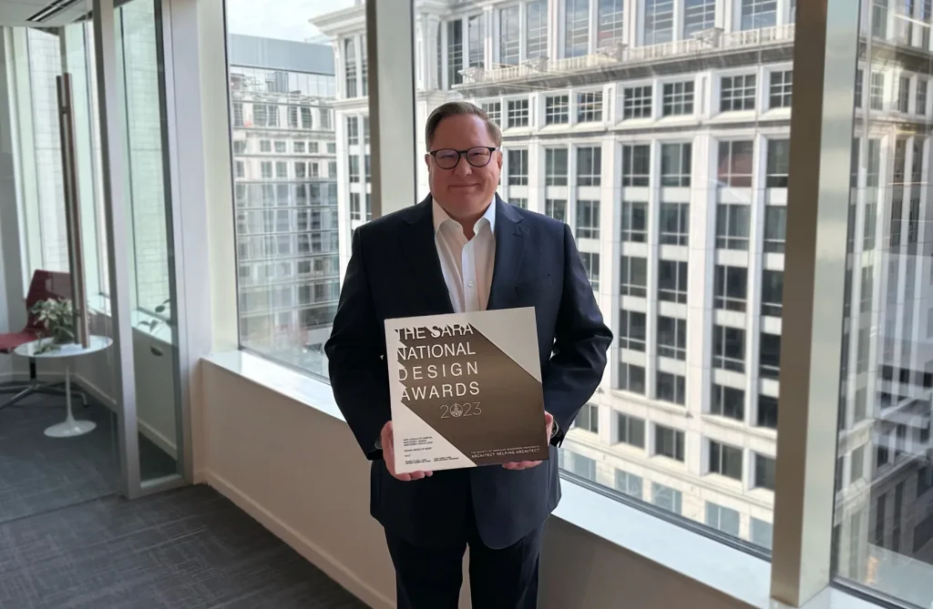 Stephen Vlach trzymający nagrodę SARA National Design Awards 2023, fot. KCCT