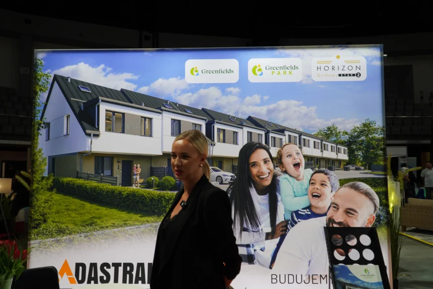 Marta Matusiak-Wójcik, Sales Manager w Adastral Invest, prezentuje ofertę domów szeregowych i mieszkań bezczynszowych podczas Warmińsko-Mazurskich Targów Nieruchomości & Budowa Domu 2025 w Olsztynie.