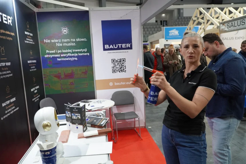 Agata Kubas z firmy Bauter demonstruje właściwości termoizolacyjne powłok cienkowarstwowych podczas Warmińsko-Mazurskich Targów Nieruchomości & Budowa Domu w Olsztynie.