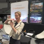 Martyna Alexander, Kierownik Działu Sprzedaży w Harmony Group, prezentuje ofertę inwestycji mieszkaniowych premium podczas targów nieruchomości w hali Urania w Olsztynie 2025.