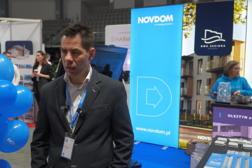 Michał Kulesza, Starszy Doradca Klienta Inwestycyjnego w Novdom, prezentuje ofertę inwestycji mieszkaniowych na targach nieruchomości w hali Urania w Olsztynie 2025.