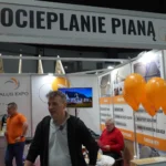 Stoisko Salus Expo na Warmińsko-Mazurskich Targach Nieruchomości & Budowa Domu 2025 w Olsztynie. Firma prezentuje swoje rozwiązania w zakresie ocieplania budynków pianą PUR oraz innymi metodami izolacji termicznej.
